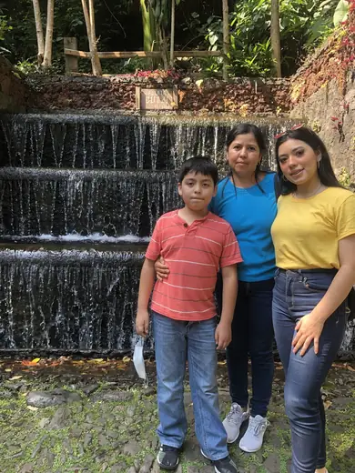 Adriel with his mother and sister in front of a stepped fountain