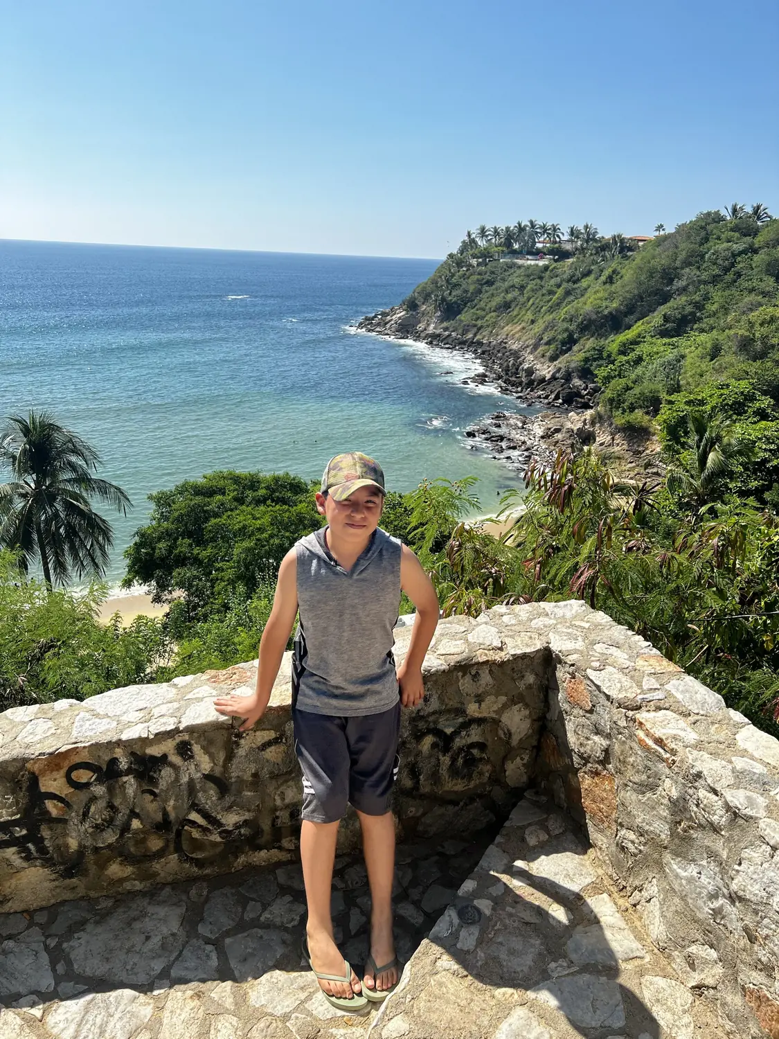 Adriel at a stone lookout above a bay in Puerto Escondido