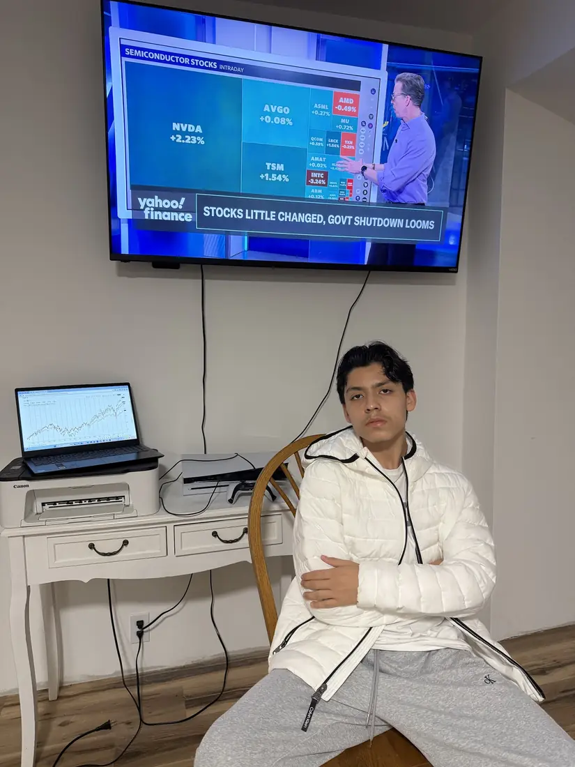 Adriel sitting with arms crossed in a white jacket